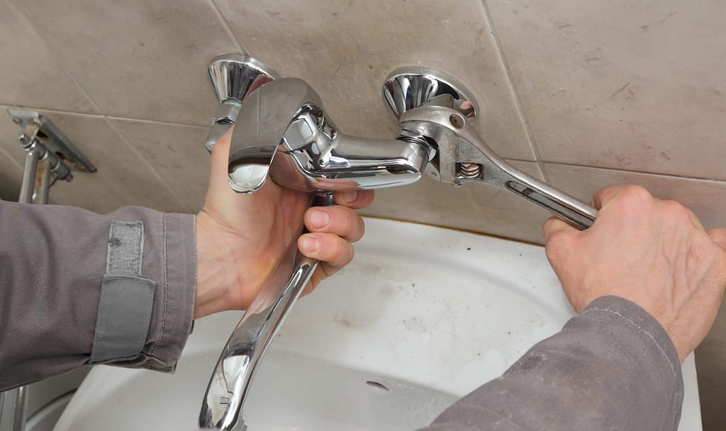 Professional plumber performing water tap replacement and faucet repair in Dubai.