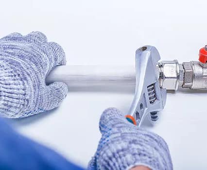 Professional plumber performing shut off valve repair and angle valve installation