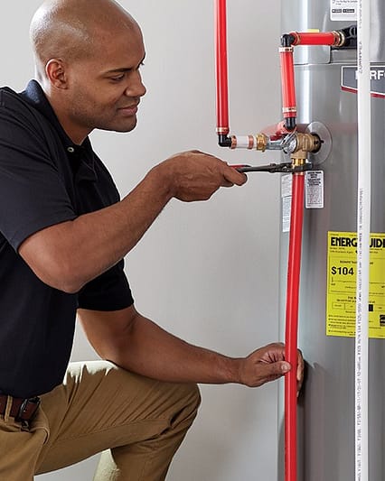 An electrician replacing old and installing new water heater in Dubai.
