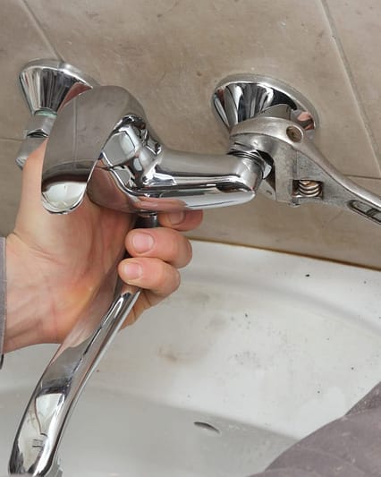 Professional plumber performing water tap replacement and faucet repair in Dubai.